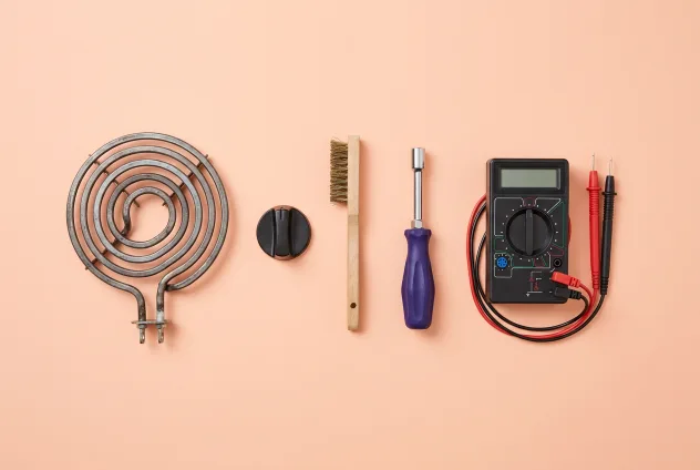 Stove repair parts and tools on a peach background